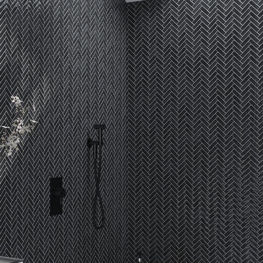 Ash gray 11x13 glossy glass mosaic tile arranged in herringbone pattern on wall