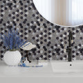 Silver honed hexagon PVC peel and stick tiles in black, dark gray, and silver on bathroom wall