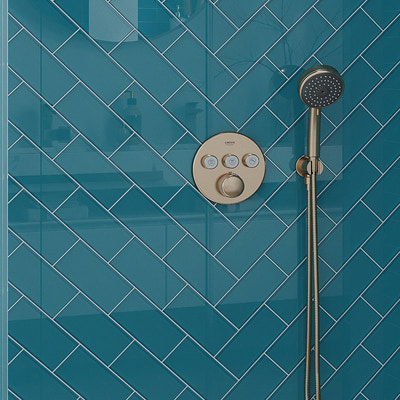 Sapphire blue glossy glass subway tiles 3x6 in herringbone pattern on shower wall