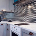 Black glossy hexagon glass mosaic tile backsplash with white grout in kitchen setting