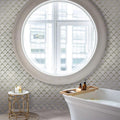 Polished white Eastern White glass and marble diamond mosaic tile on bathroom wall around circular window