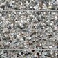 Black terrazzo subway tile with amber pearl flecks and glossy shell finish in 3x12 elongated shape