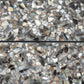 Black shell terrazzo elongated subway tile with amber pearl flecks and glossy finish
