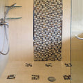 Beige gray polished square glass resin stone mosaic tile on shower wall and floor accents