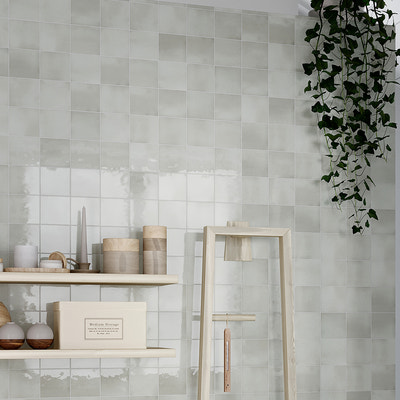 glossy tea green 4x4 ceramic square tiles installed on wall with subtle color variation