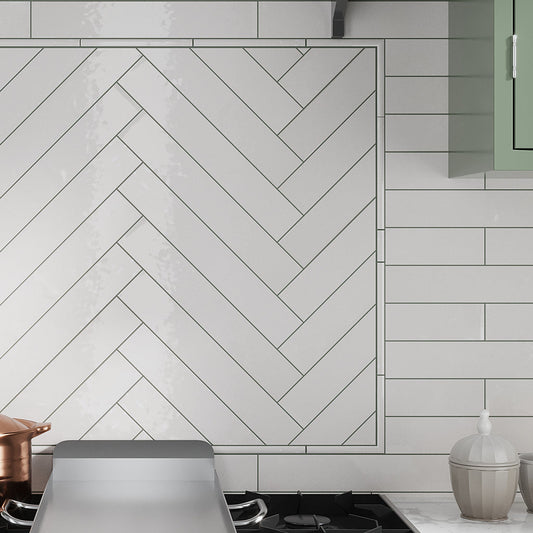 Ivory white glossy ceramic subway tile 2.6x16 inches installed as kitchen backsplash wall