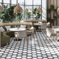 Matte white and black porcelain hexagon tiles with subtle veining on a commercial floor