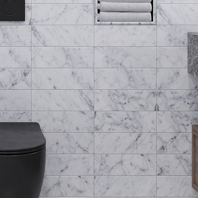 Polished white Bianco Carrara marble subway tile 4x12 installed on bathroom wall