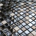 Glossy black, silver, and textured mosaic glass and metal square tiles arranged in a grid pattern