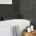 Polished sable black hexagon porcelain mosaic tile with white and gold veining on bathroom wall