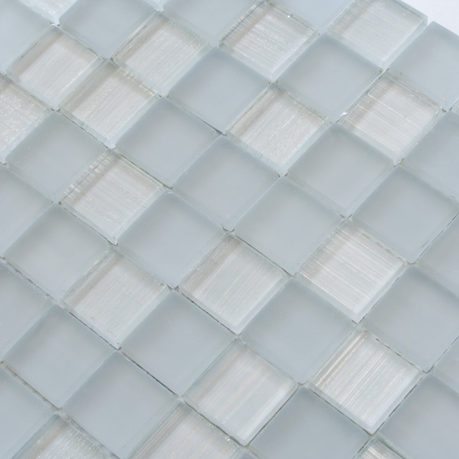 Close-up of Could Gray 11x11 glossy and matte square glass mosaic tiles in mixed textures