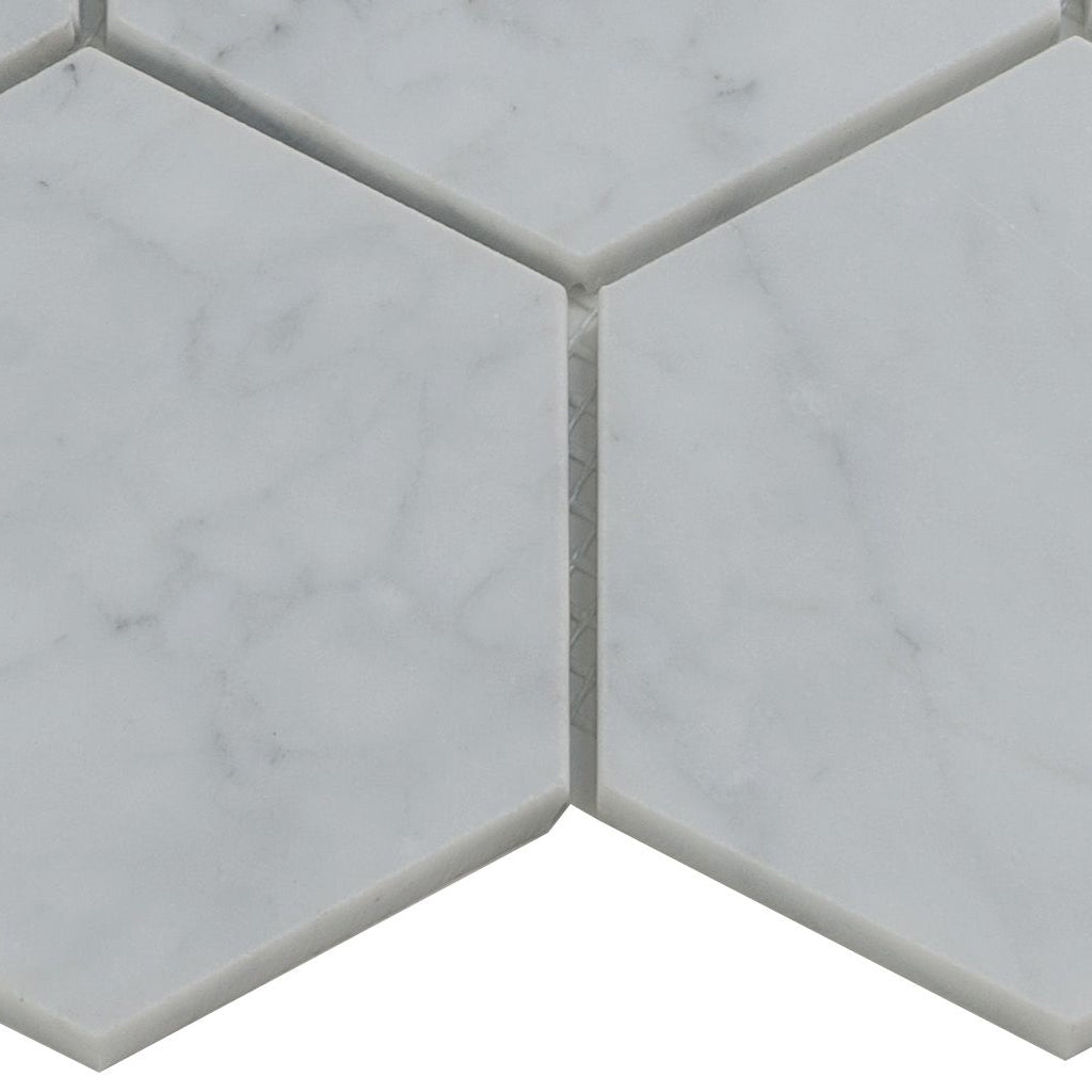 white honed marble hexagon mosaic tile with subtle gray veining close-up