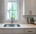 white polished bianco carrara marble herringbone mosaic tile backsplash installed in kitchen