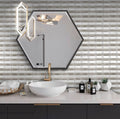 White polished marble mosaic tiles with gray accents in a stacked brick pattern on bathroom wall