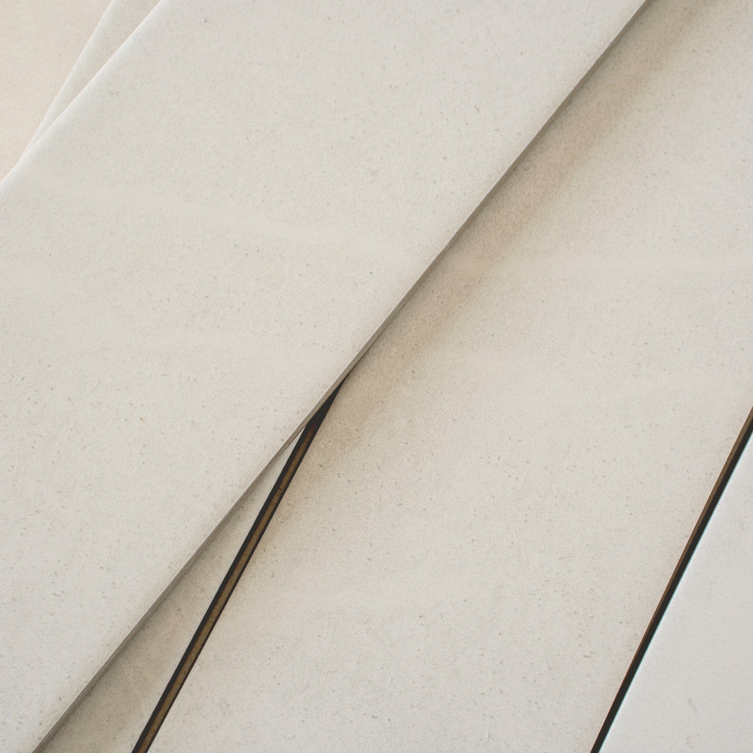 Soft white matte porcelain plank tiles in 3x24 size showcasing smooth texture and subtle speckled pattern