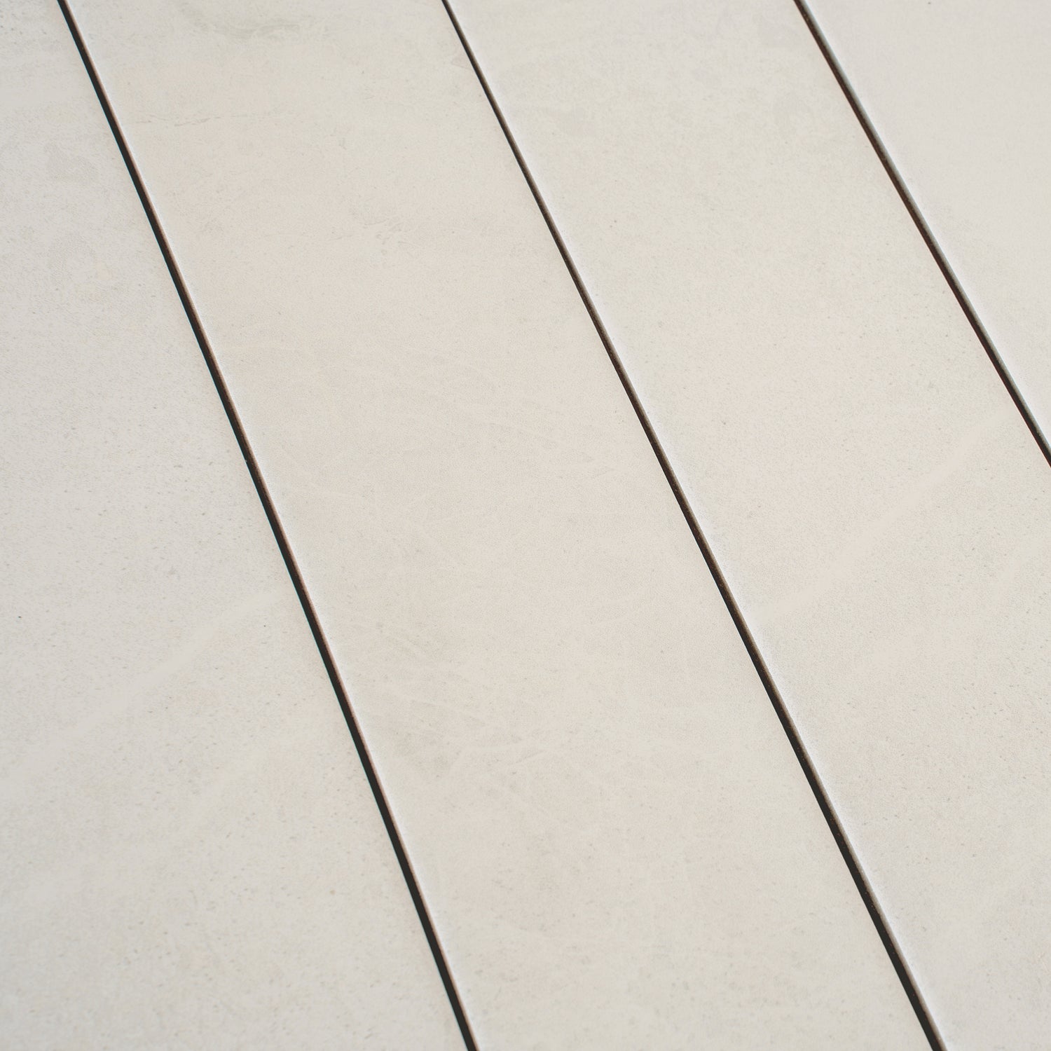 Soft white matte porcelain plank tile in 3x24 inch size with subtle texture and light veining