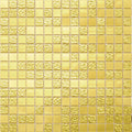 Glossy gold yellow 12x12 glass mosaic tiles with smooth and textured square pieces arranged in a grid