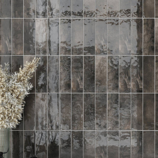Black glossy ceramic subway tile 2.5x8 inches installed on wall surfaces