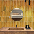Honey orange glossy ceramic subway tile 2.5x8 inches on bathroom wall