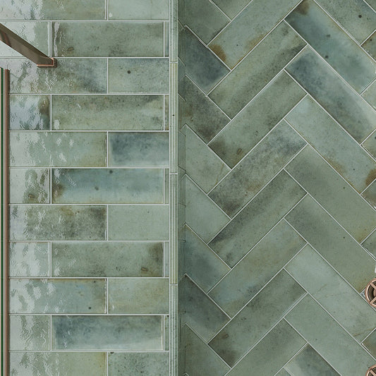 Glossy sage green ceramic subway tile wall and floor in horizontal and herringbone patterns