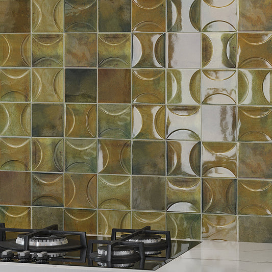 Glossy olive green 4x4 ceramic square tiles with circular design on kitchen backsplash