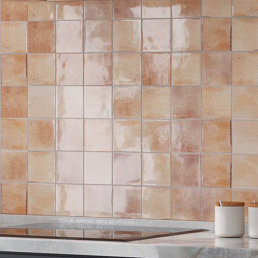 Glossy 4x4 pink ceramic square tiles installed as kitchen backsplash wall