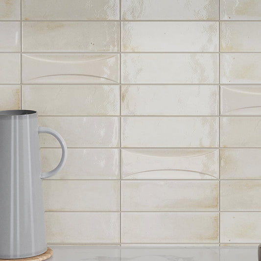 Glossy white 2.5x8 ceramic subway tile with wavy texture on a kitchen backsplash wall