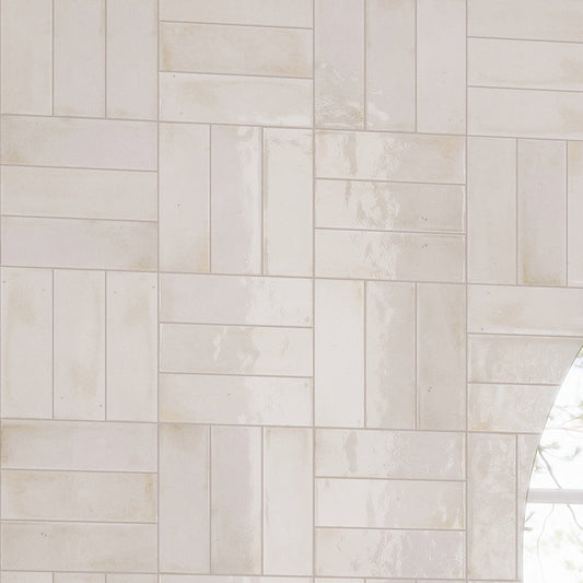Glossy white 2.5x8 ceramic subway tiles arranged in staggered geometric pattern