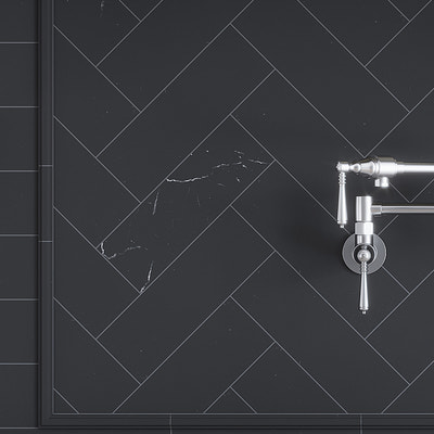 black honed marble subway tile 4x12 arranged in herringbone on wall with metallic fixture