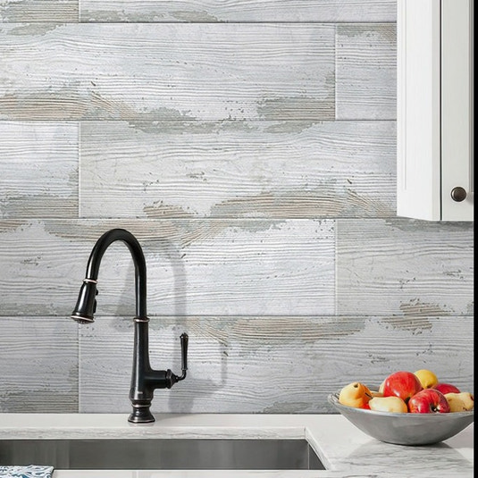 Light gray matte porcelain wood-look tile in rectangular planks installed as kitchen backsplash and wall tile
