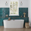 Glossy ocean green 5x5 ceramic subway tile installed on bathroom wall