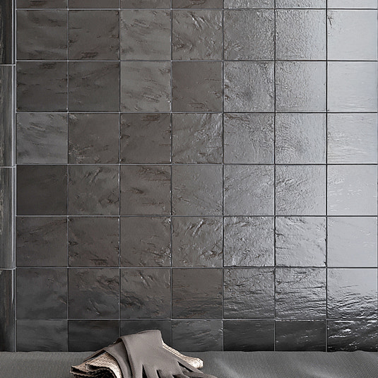 Black glossy and matte ceramic 4x4 square tiles on a wall surface