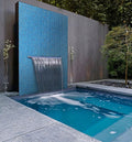 Glossy electric blue 12x12 glass mosaic tiles installed on an outdoor water feature wall