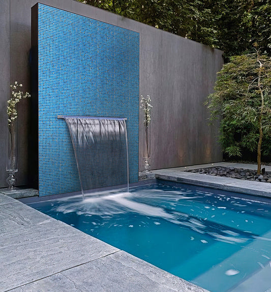 Glossy electric blue 12x12 glass mosaic tiles installed on an outdoor water feature wall