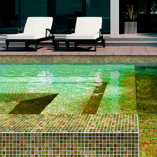 Green and gold glossy square glass mosaic tiles installed on a swimming pool floor and walls