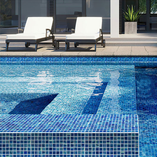 Deep sea blue glossy glass mosaic square tiles installed on pool flooring and edges