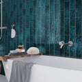 Glossy teal green ceramic subway tile 2.5x8 inches on bathroom wall surrounding bathtub