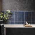 Dark blue glossy square ceramic subway tiles 5x5 installed on bathroom wall