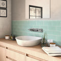 Matte blizzard blue glass subway tiles 3x6 installed as bathroom backsplash
