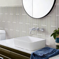 Beige glossy glass subway tiles, 4x16 inches, installed on bathroom wall