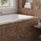 taupe matte recycled glass square mosaic tiles installed around bathtub wall and ledge