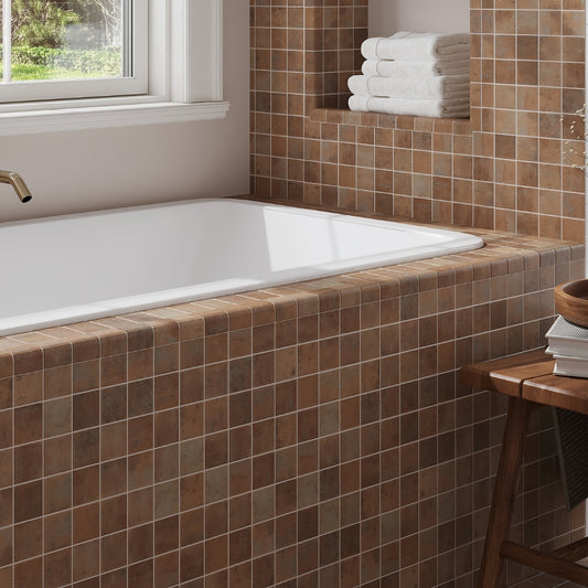 taupe matte recycled glass square mosaic tiles installed around bathtub wall and ledge