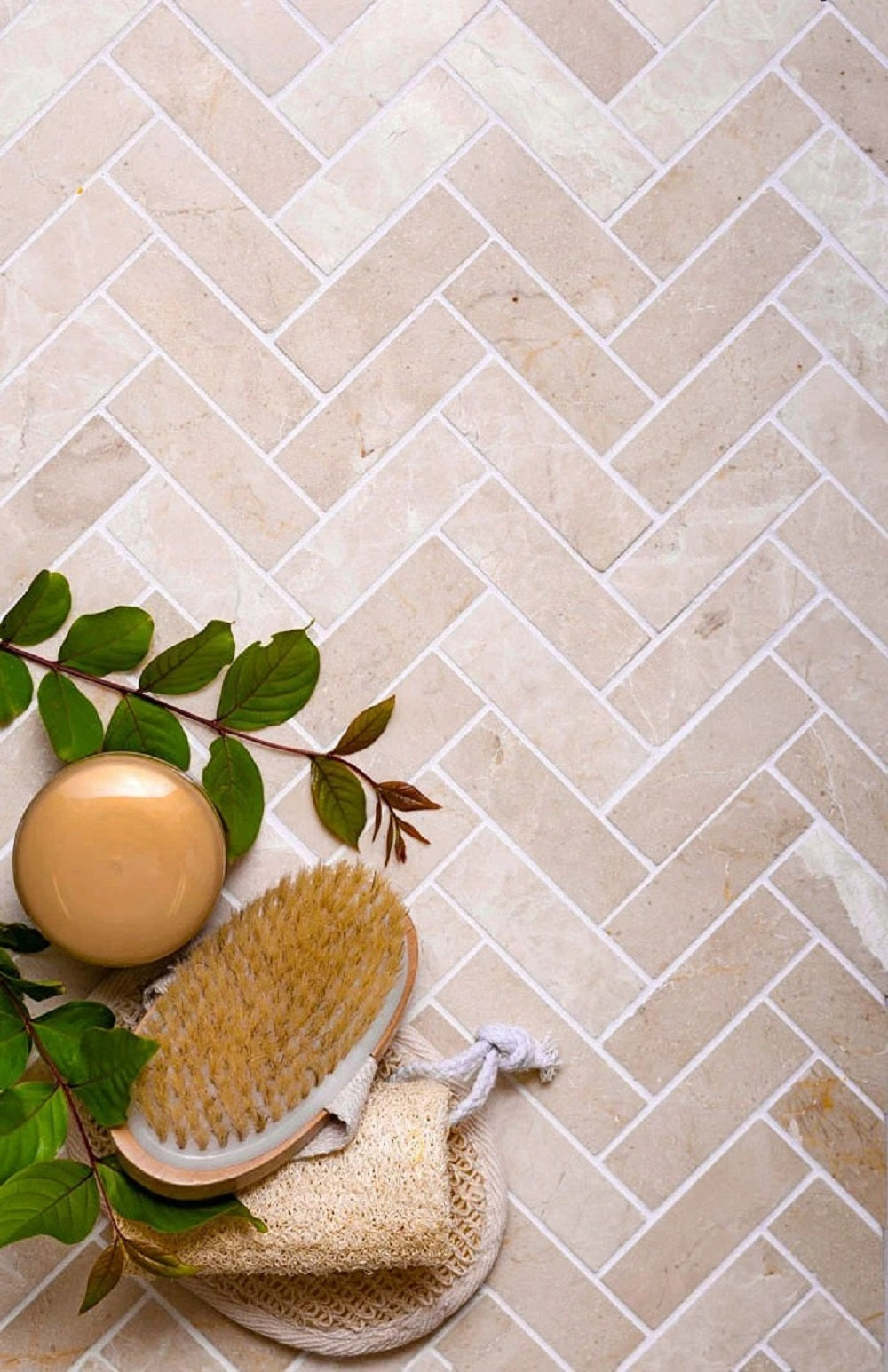 Ivory beige 12x12 polished Crema Marfil marble tiles arranged in herringbone mosaic pattern