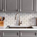 Polished white marble subway mosaic tile with dot accents on kitchen backsplash