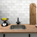 White honed Thassos marble subway tile 3x6 installed on a kitchen backsplash