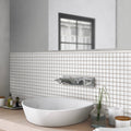 White matte glass pencil tile trim with square grid pattern, installed as bathroom wall